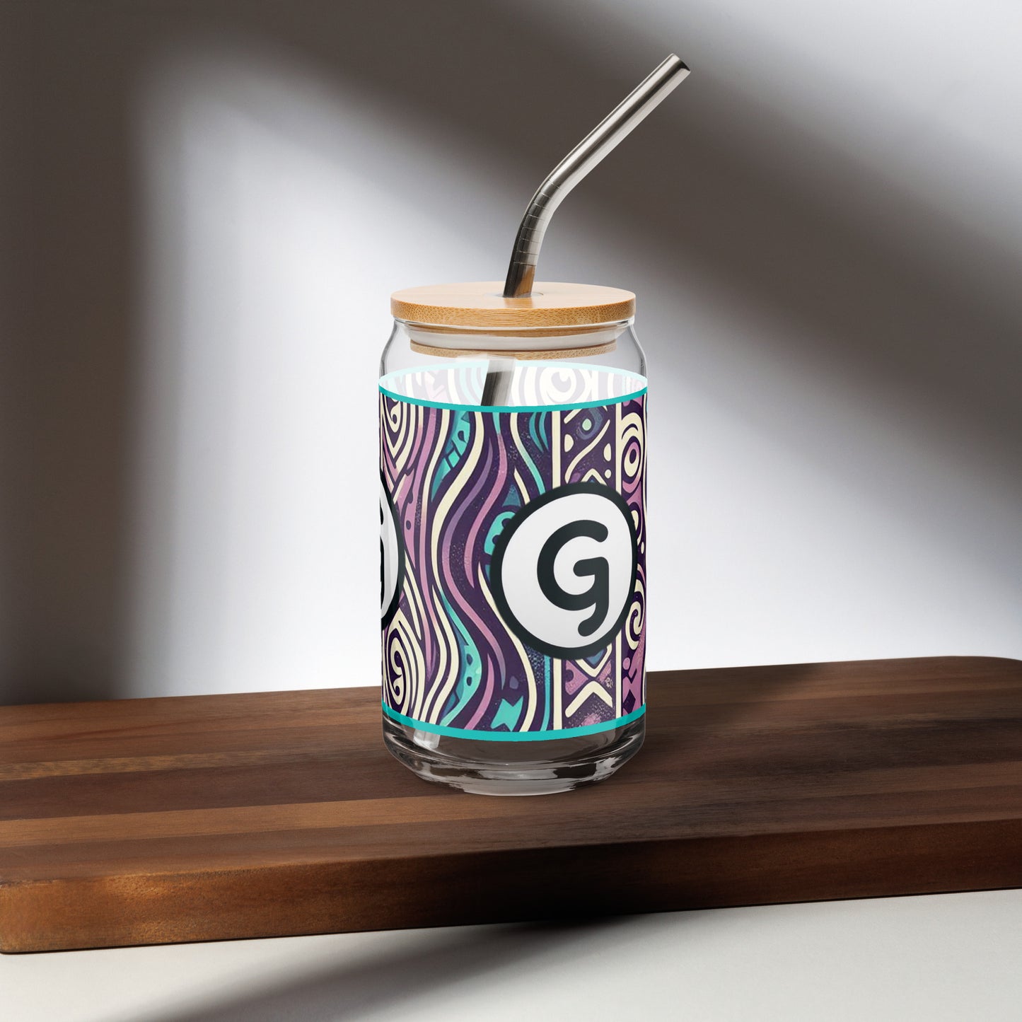 Left of can-shaped glassware with 'g' girlish logo on teal, purple, black, and white patterned background