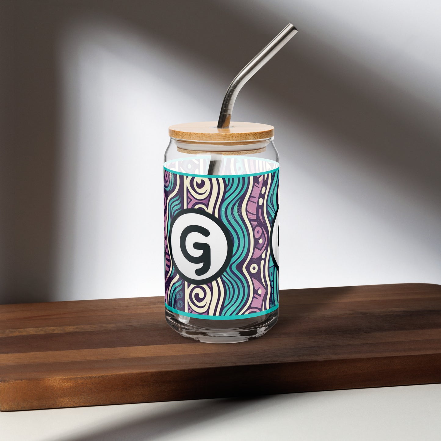 Right of can-shaped glassware with 'g' girlish logo on teal, purple, black, and white patterned background