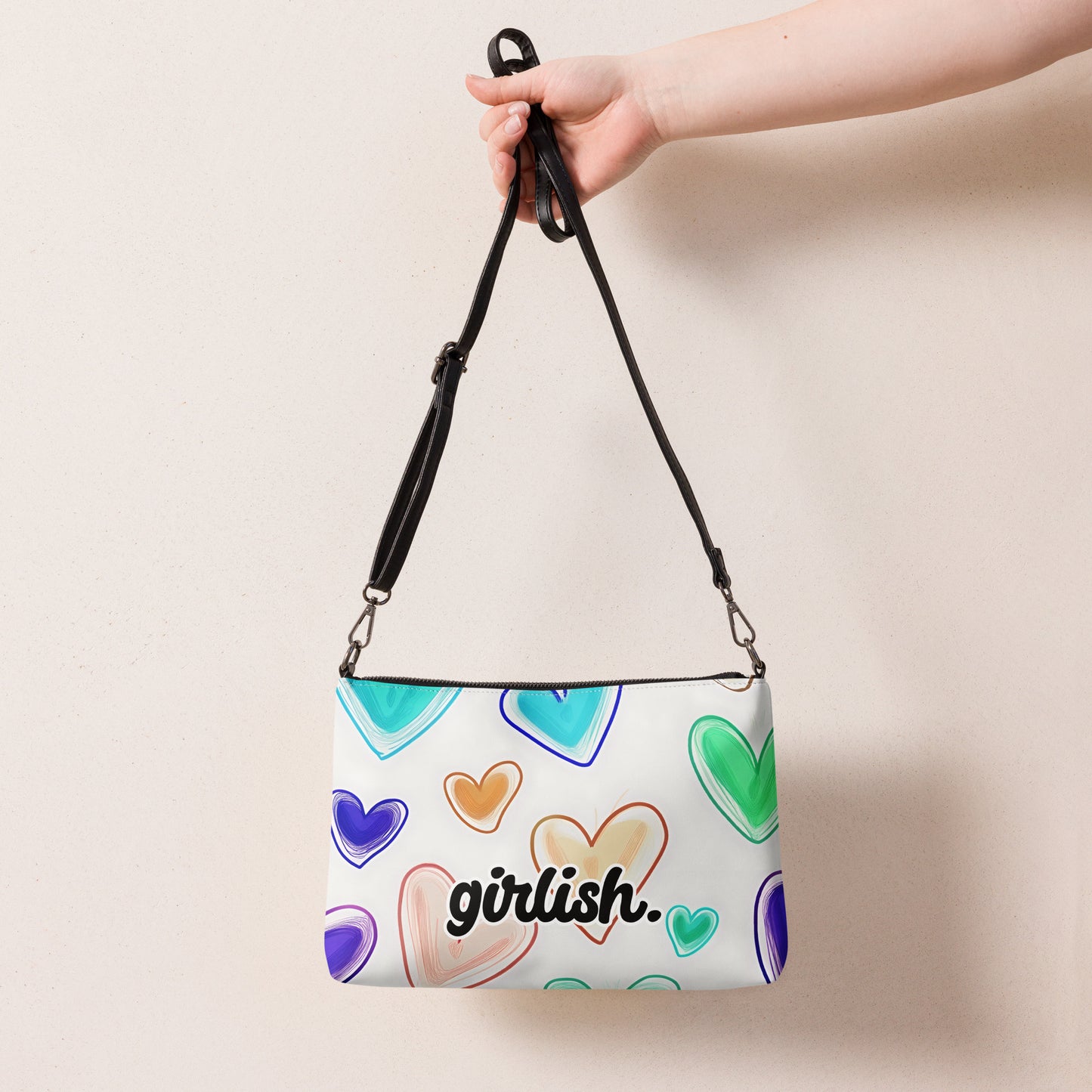 Front of crossbody bag with hearts on white background with'girlish' text