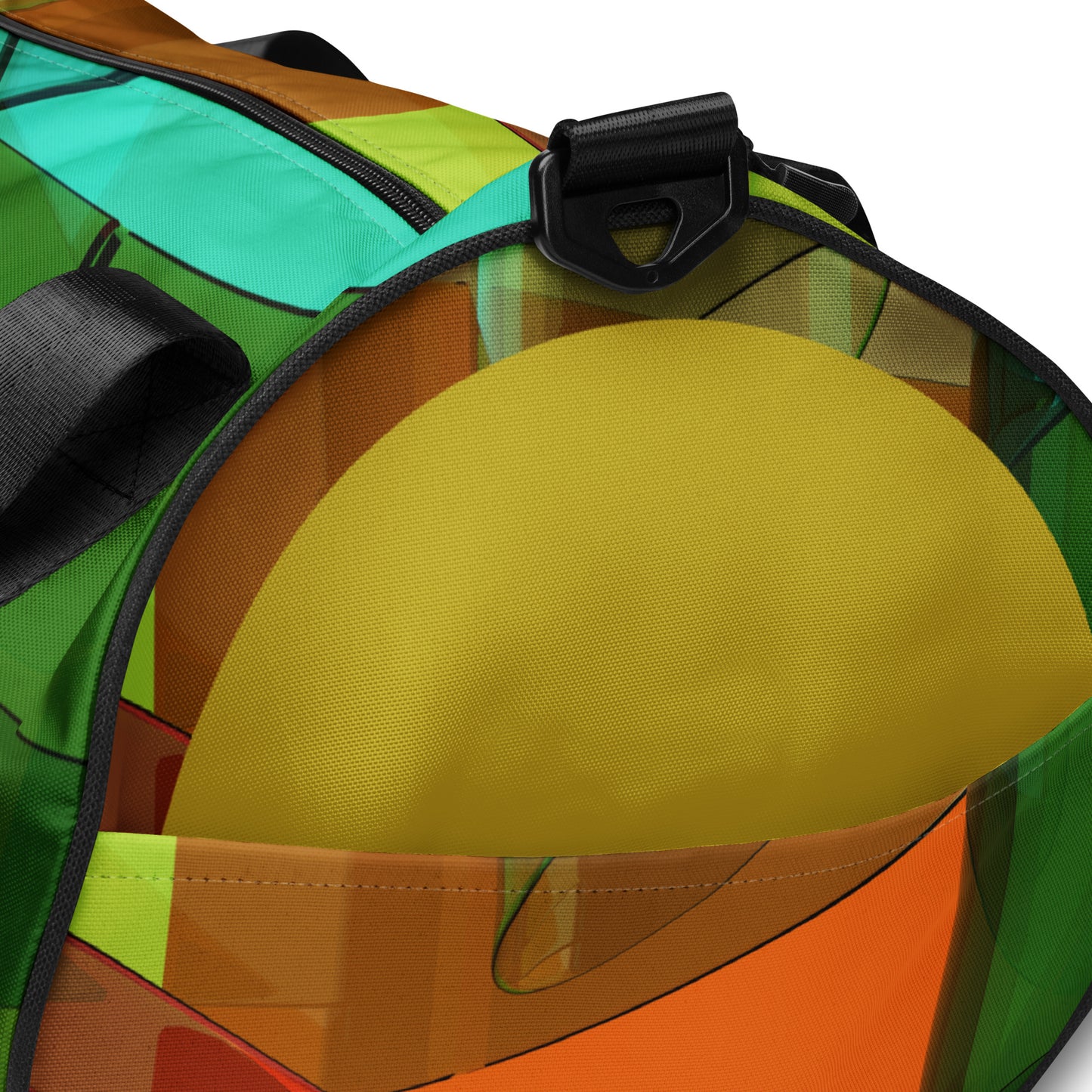 Details of end of gym bag with on square pattern of brown, red, green, and gold background and green circle