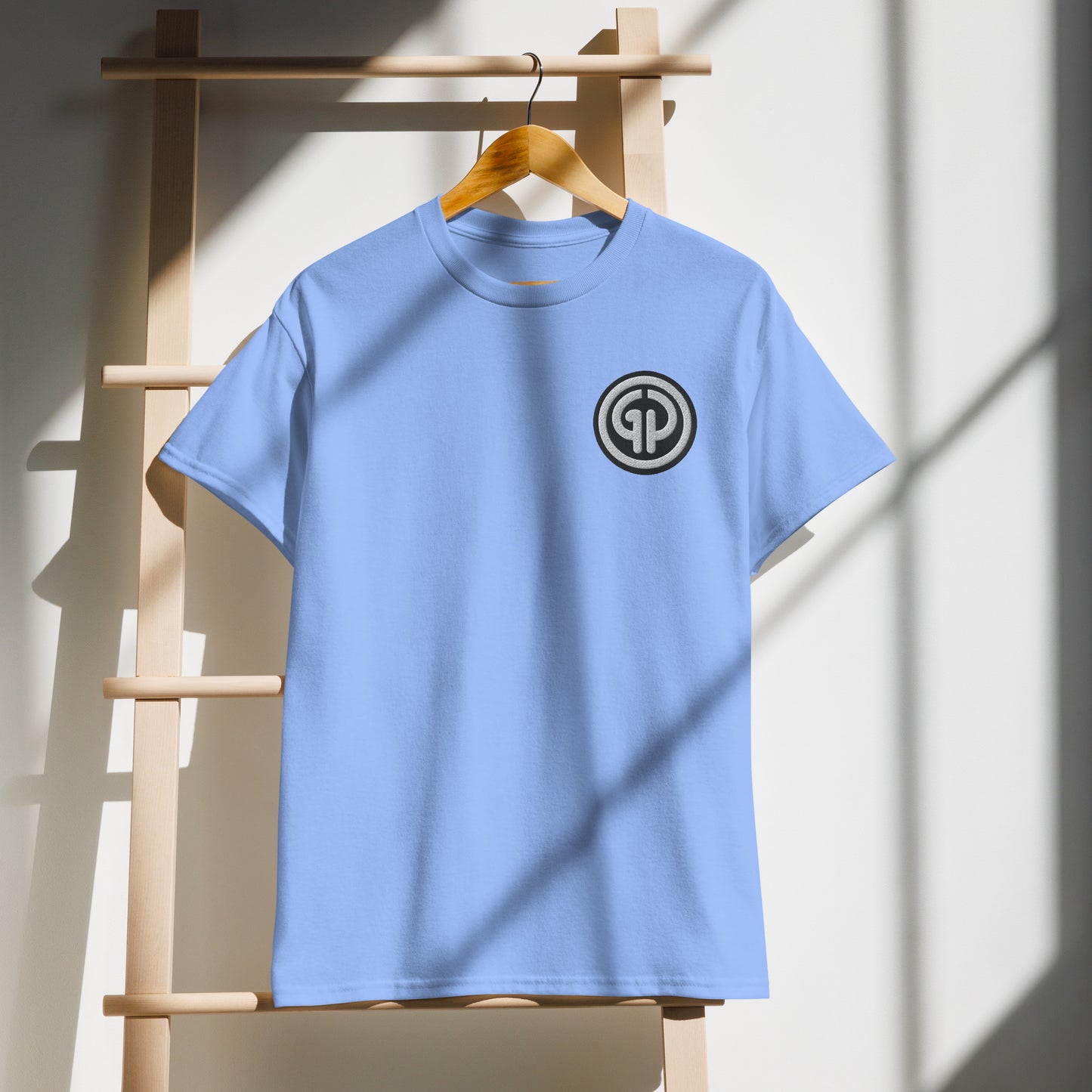 Front of hanging carolina blue t-shirt with God's Property 'GP' emblem embroidered on left chest