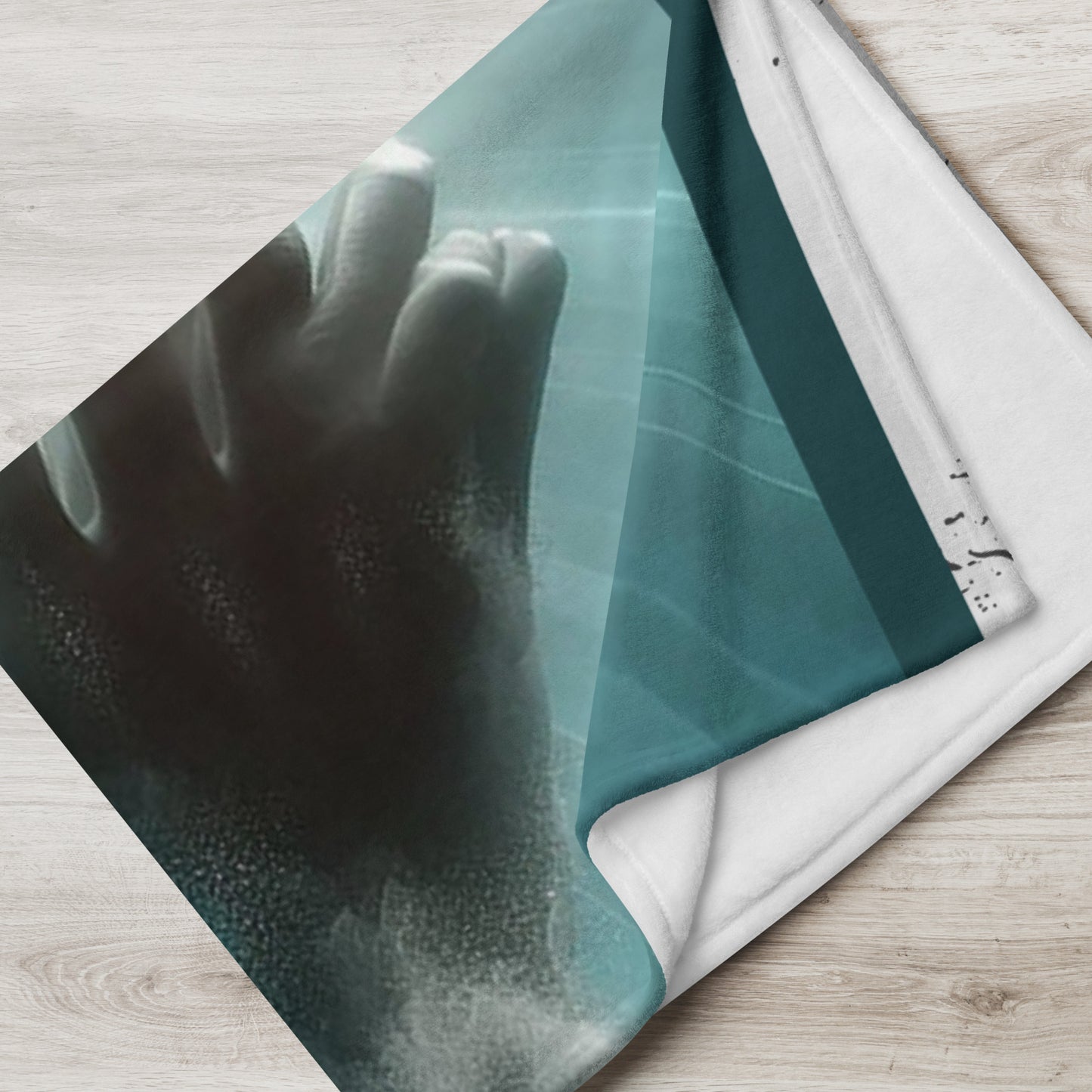 Folded blue, white and gray 50x60 throw blanket with image of praying hands