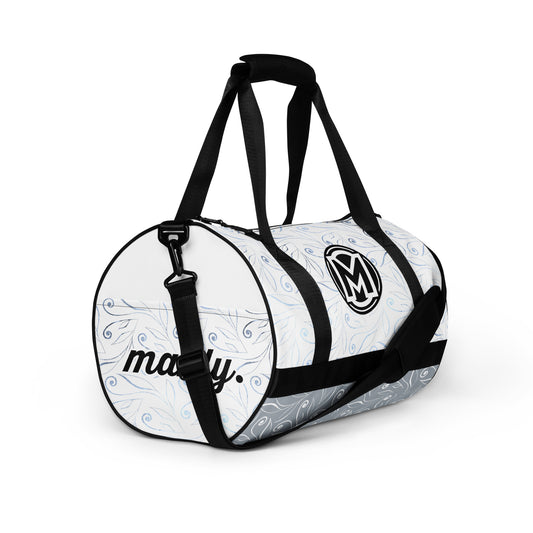 Right front of light blue gym bag with blue swirl background and 'M' logo and text 'manly'