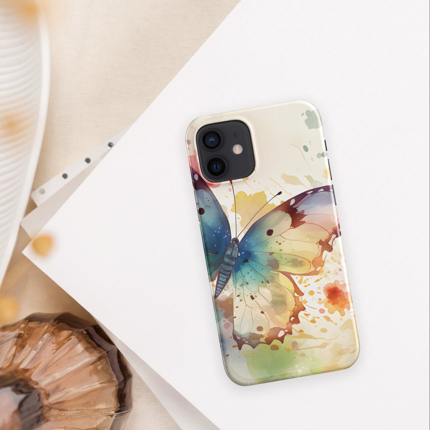 Front of iPhone 12 case with watercolor print of large butterfly of blue and other colors