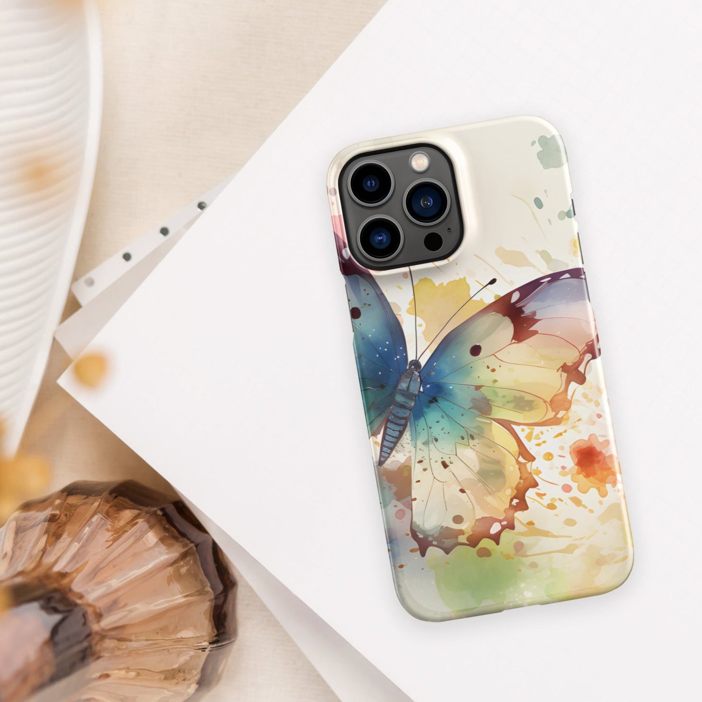 Front of iPhone 13 pro max case with watercolor print of large butterfly of blue and other colors