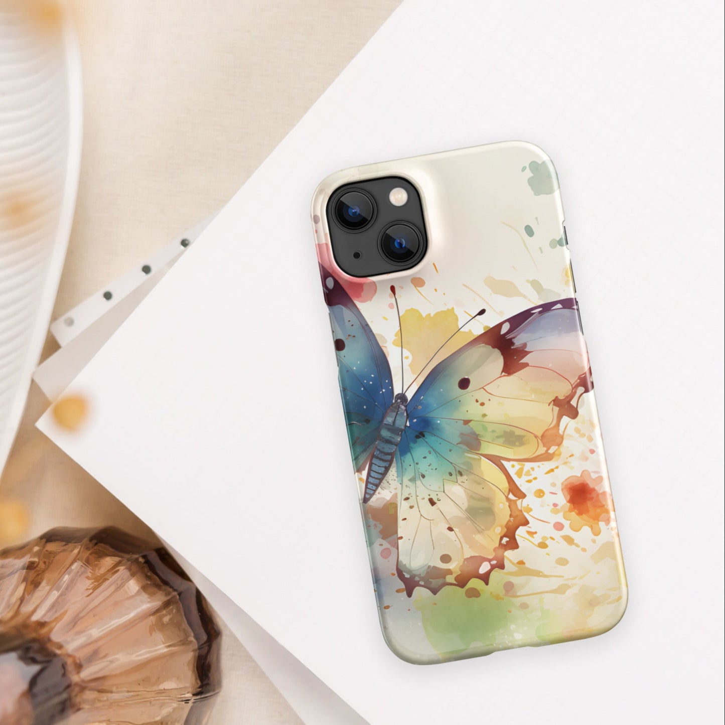Front of iPhone 14 plus case with watercolor print of large butterfly of blue and other colors