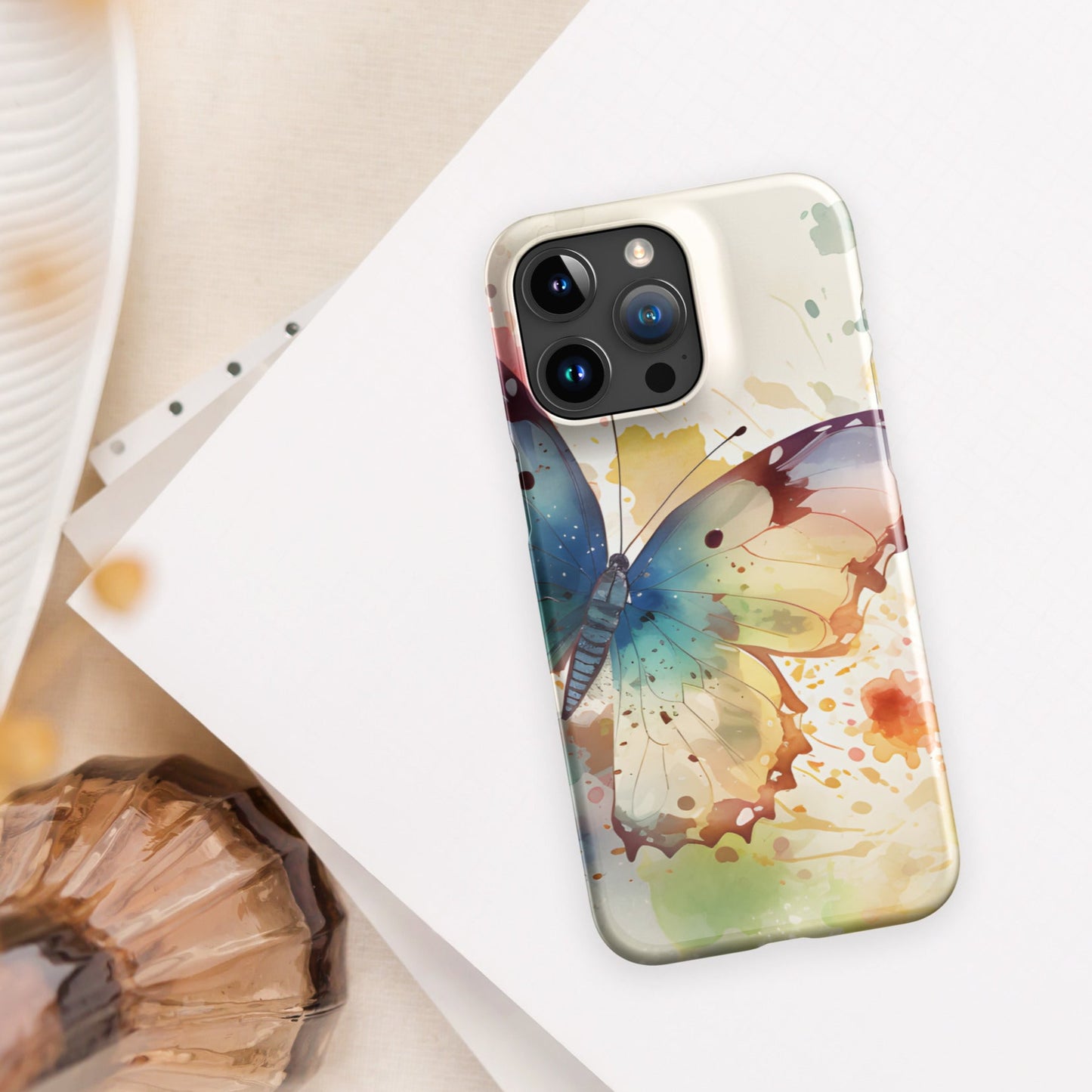 Front of iPhone 15 pro max case with watercolor print of large butterfly of blue and other colors