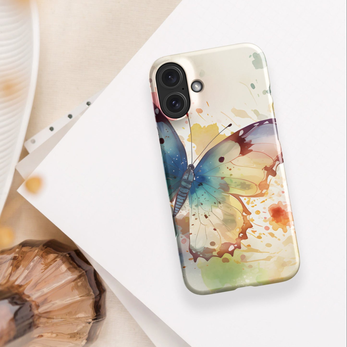Front of iPhone 16 plus case with watercolor print of large butterfly of blue and other colors