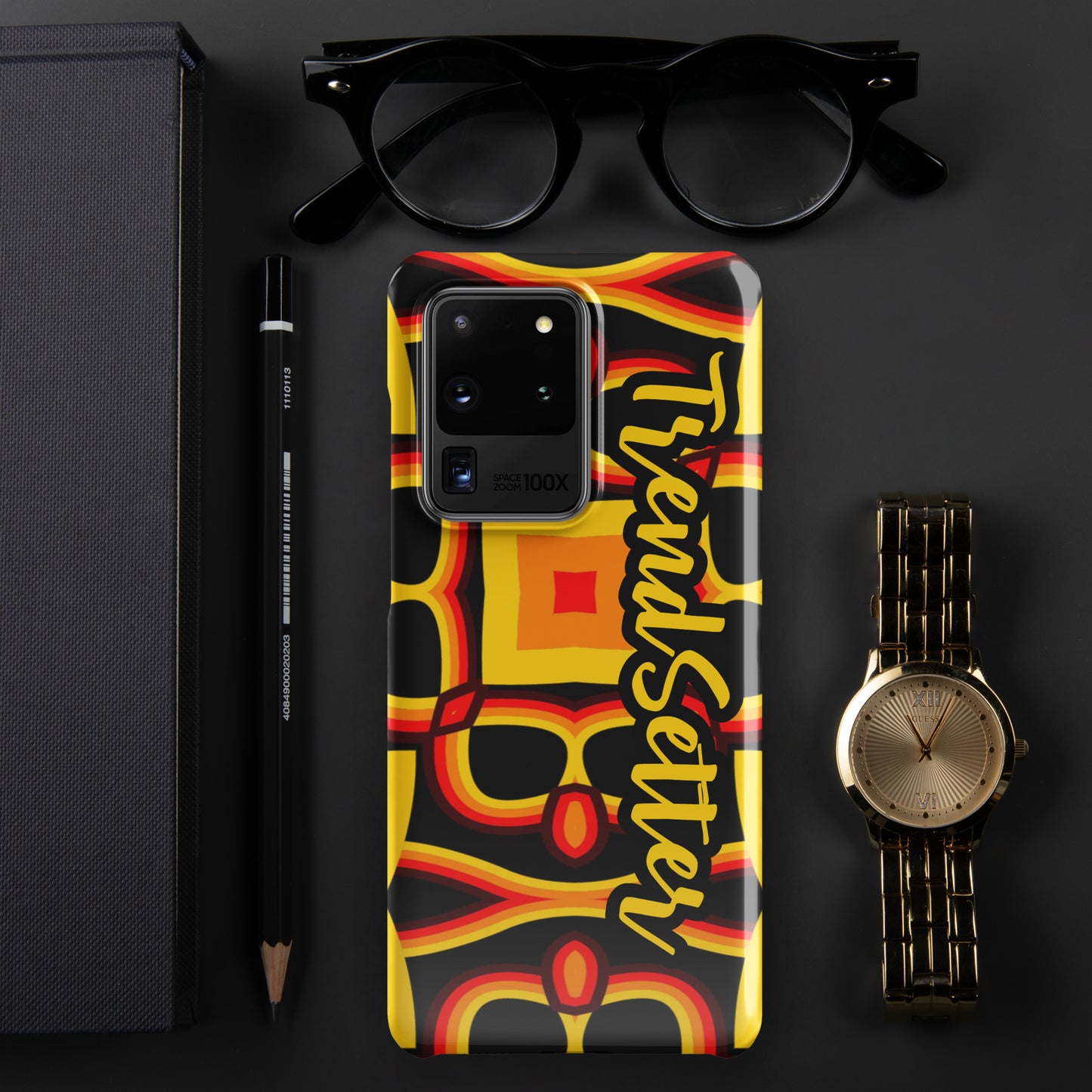 Front of gold, yellow, red and black print Samsung s20 glossy case with text "TrendSetter' in black and gold