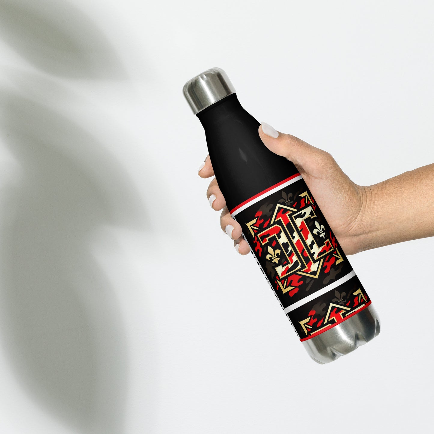 Left of black water bottle with gold red and white design with letters 'D' and 'C" as part of the design