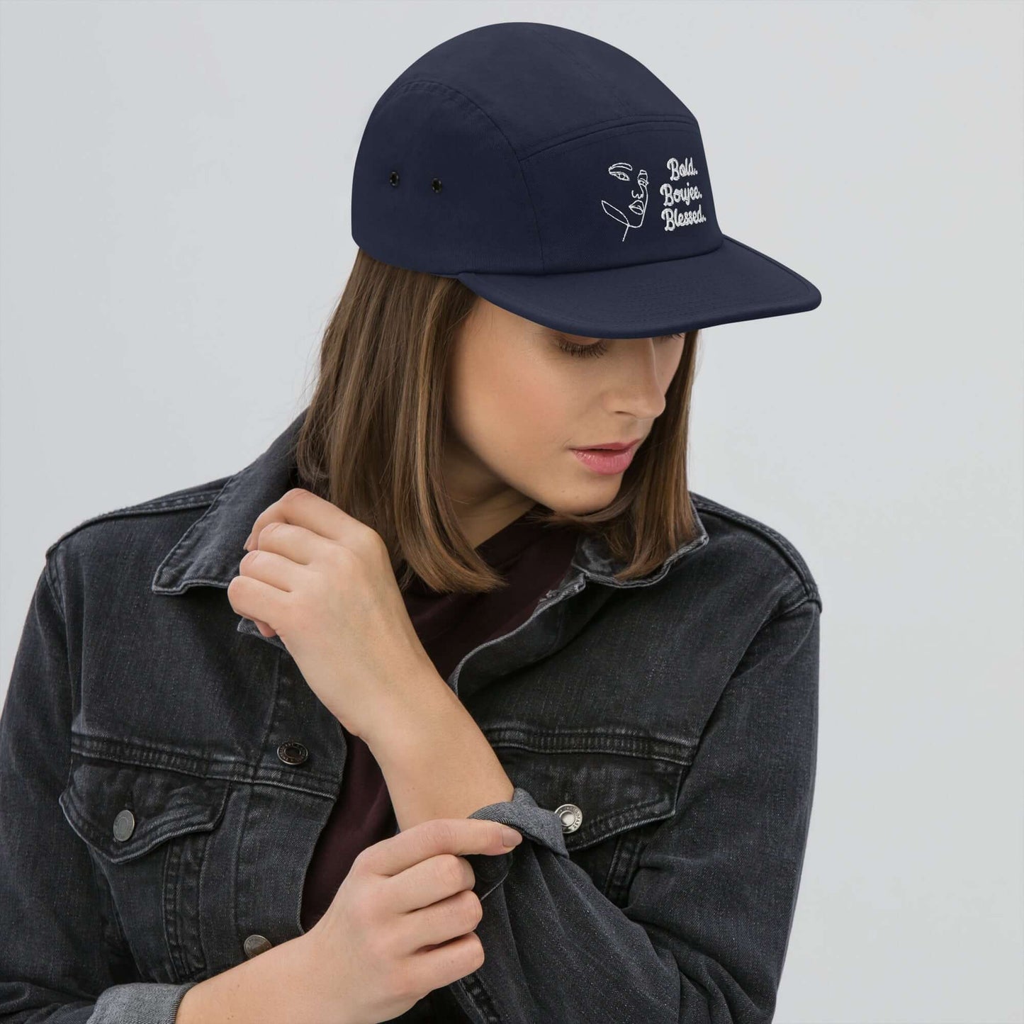 Woman wearing a navy five-panel cap with white text saying Bold, Boujee, Blessed