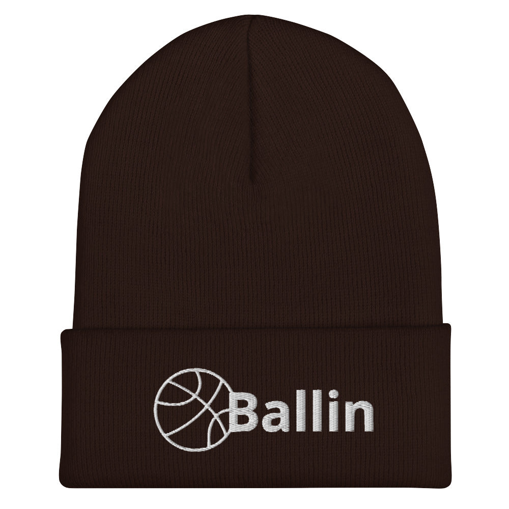 Front of brown cuffed beanie with white logo of basketball and word saying 'ballin'