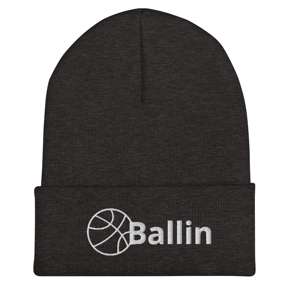 Front of gray cuffed beanie with white logo of basketball and word saying 'ballin'