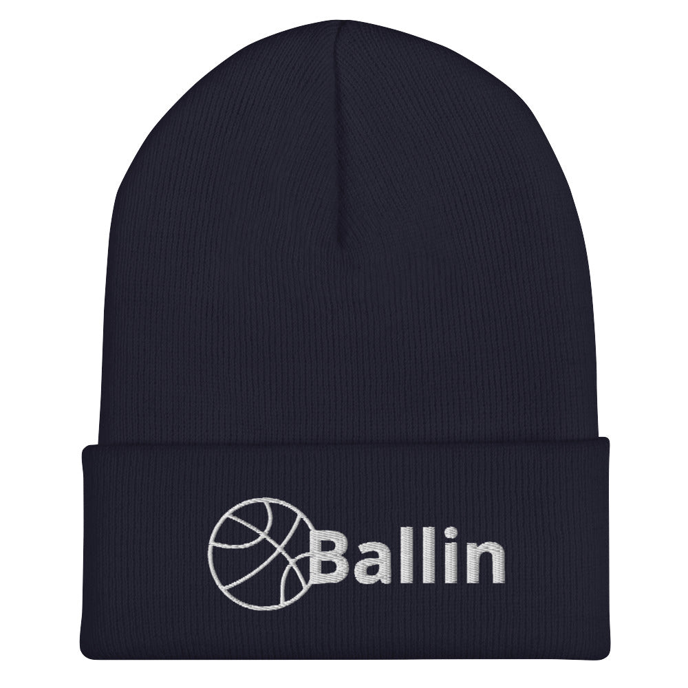 Front of navy cuffed beanie with white logo of basketball and word saying 'ballin'