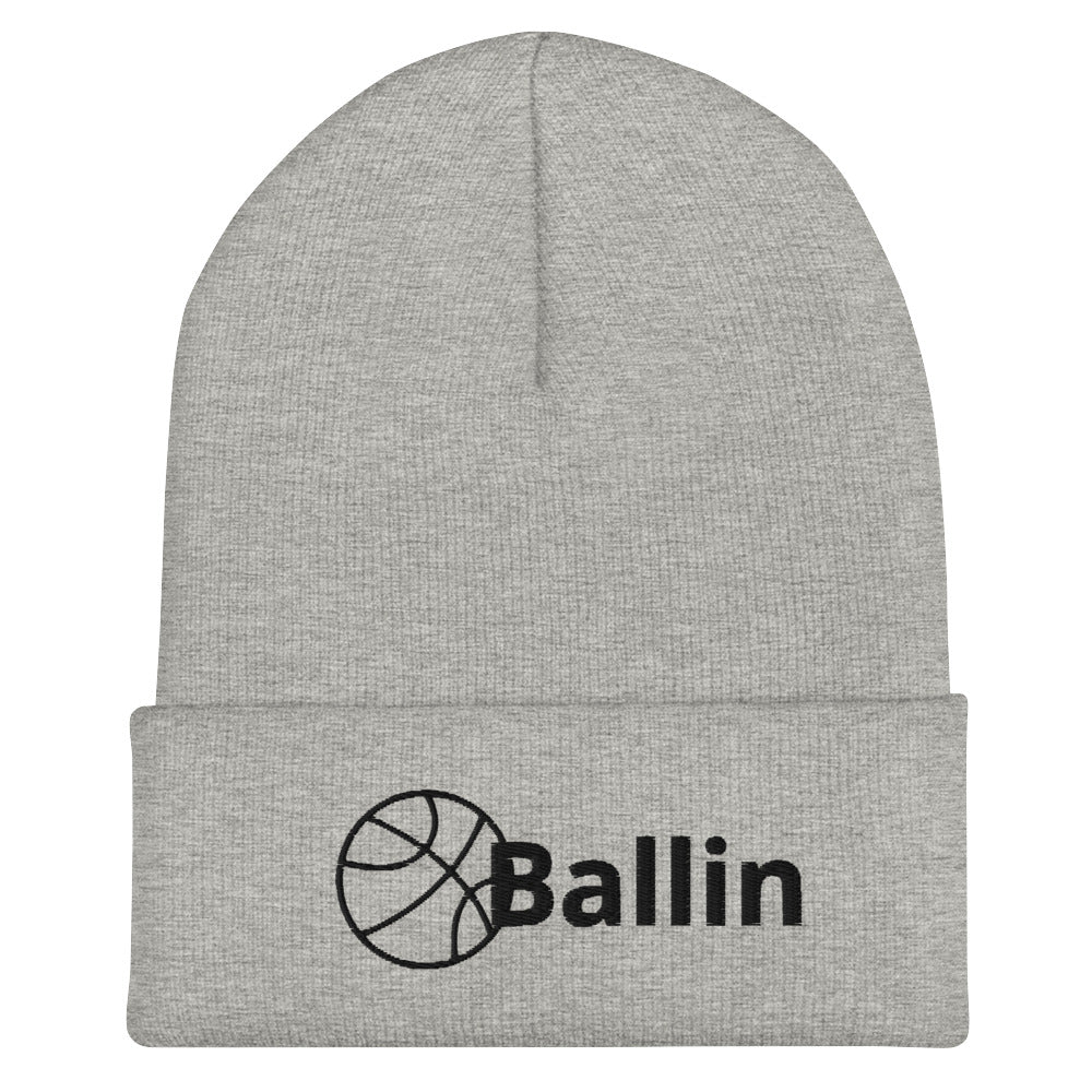 Front of grey cuffed beanie with black logo of basketball and word saying 'ballin'