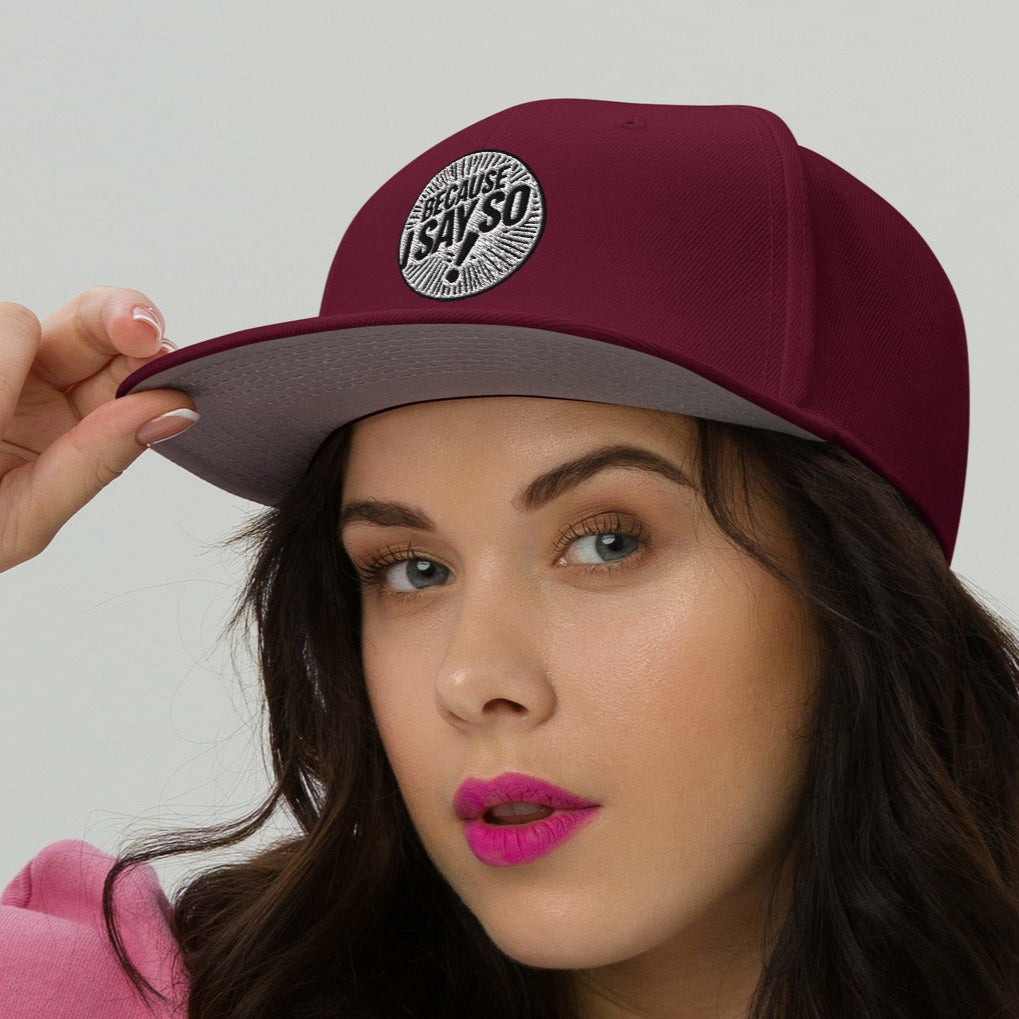 Front of burgundy cap being worn by a woman with logo 'because i say so" on front