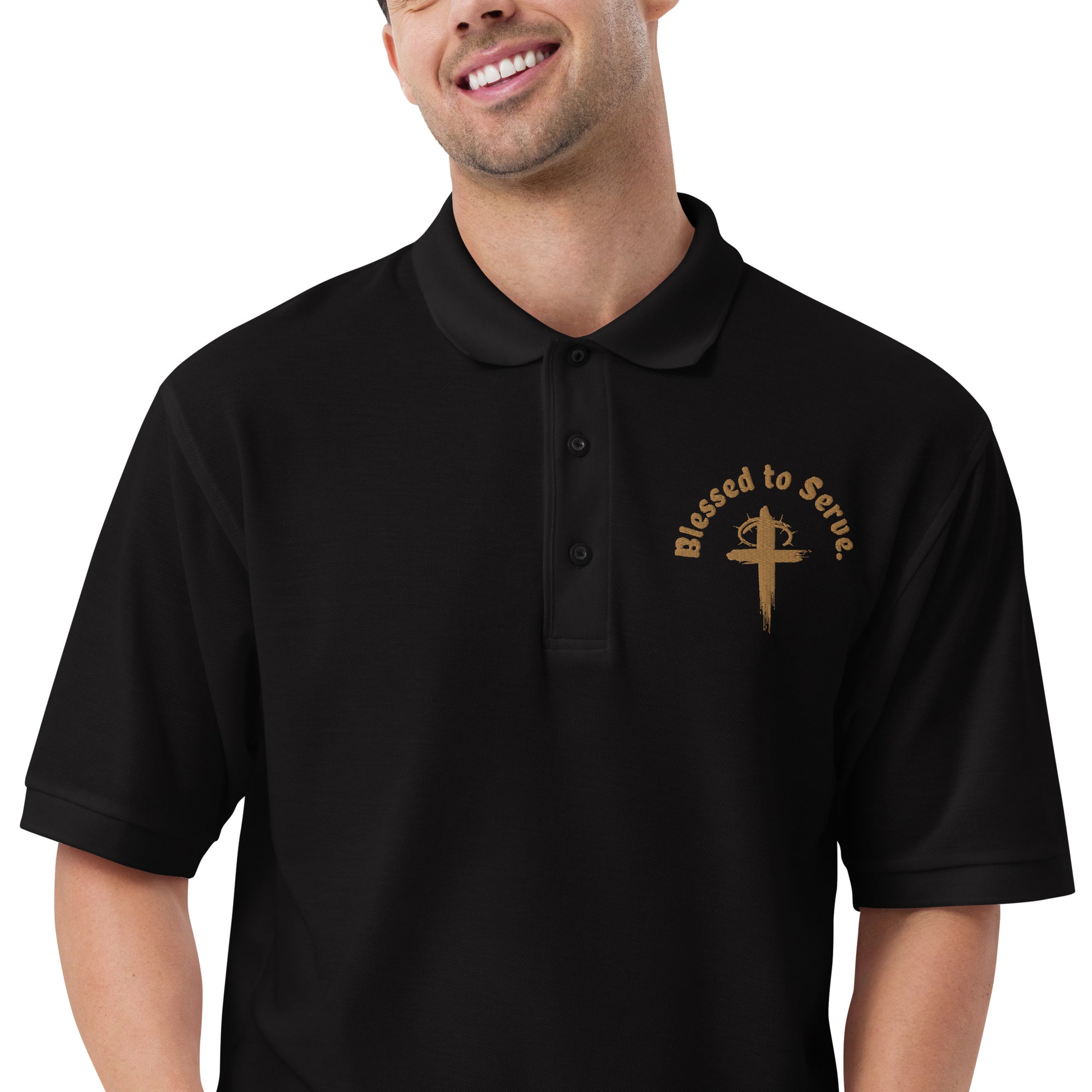 Front zoomed of black polo with tan cross and tan text saying 'blessed to serve'