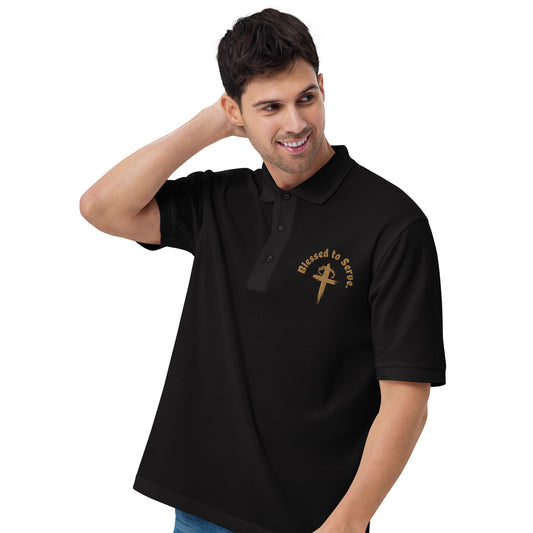 Left front of black polo with tan cross and tan text saying 'blessed to serve'