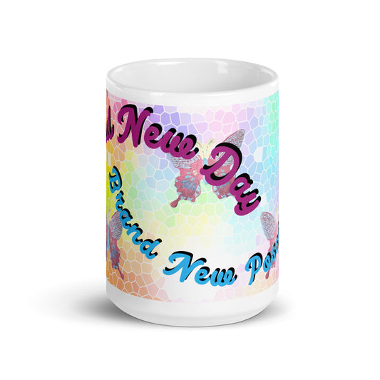 Front view of a white mug with mosaic butterfly background and purple text saying 'A New day' on top and blue text saying 'brand new possibilities' on the bottom