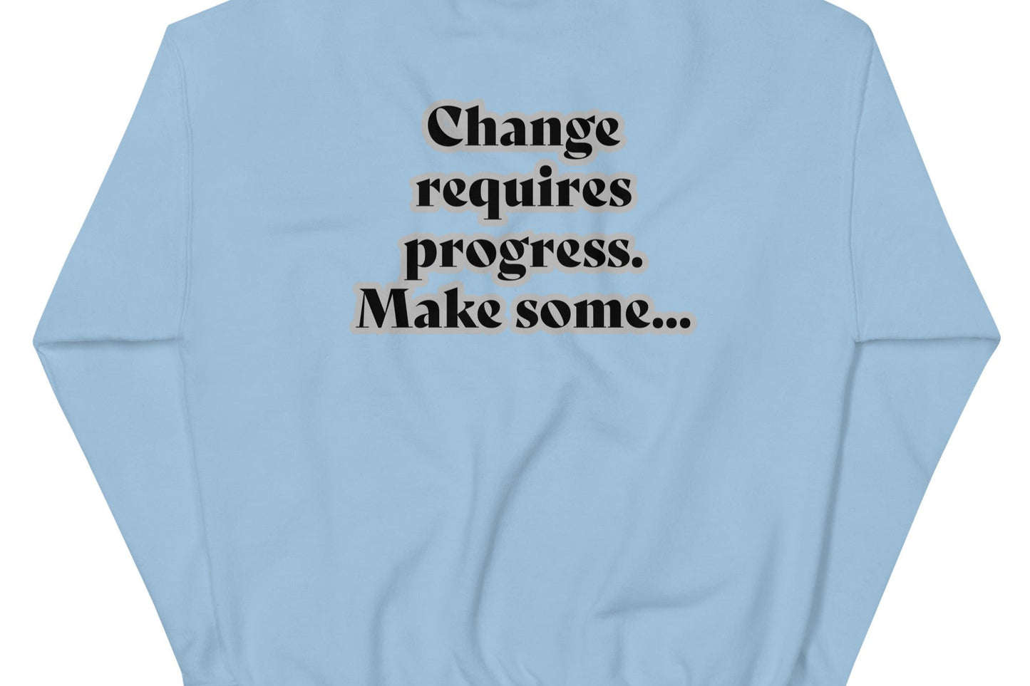 Back of light-blue sweatshirt with black text outlined in white saying 'Change requires progress. Make some...'