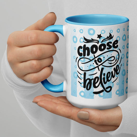 Left view of a white mug with light blue inside and outside in light blue and white lines and circle background, and black text saying 'choose to believe'