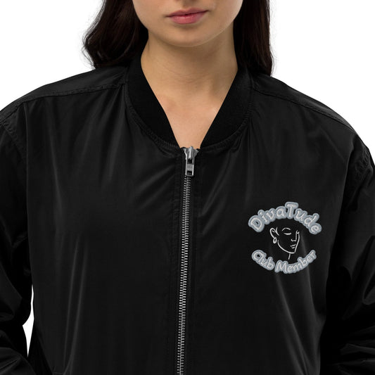 Front of black bomber jacket with image on top left of embroidered lady's face in white and grey and black text saying "DivaTude' above and 'Club Member' below 