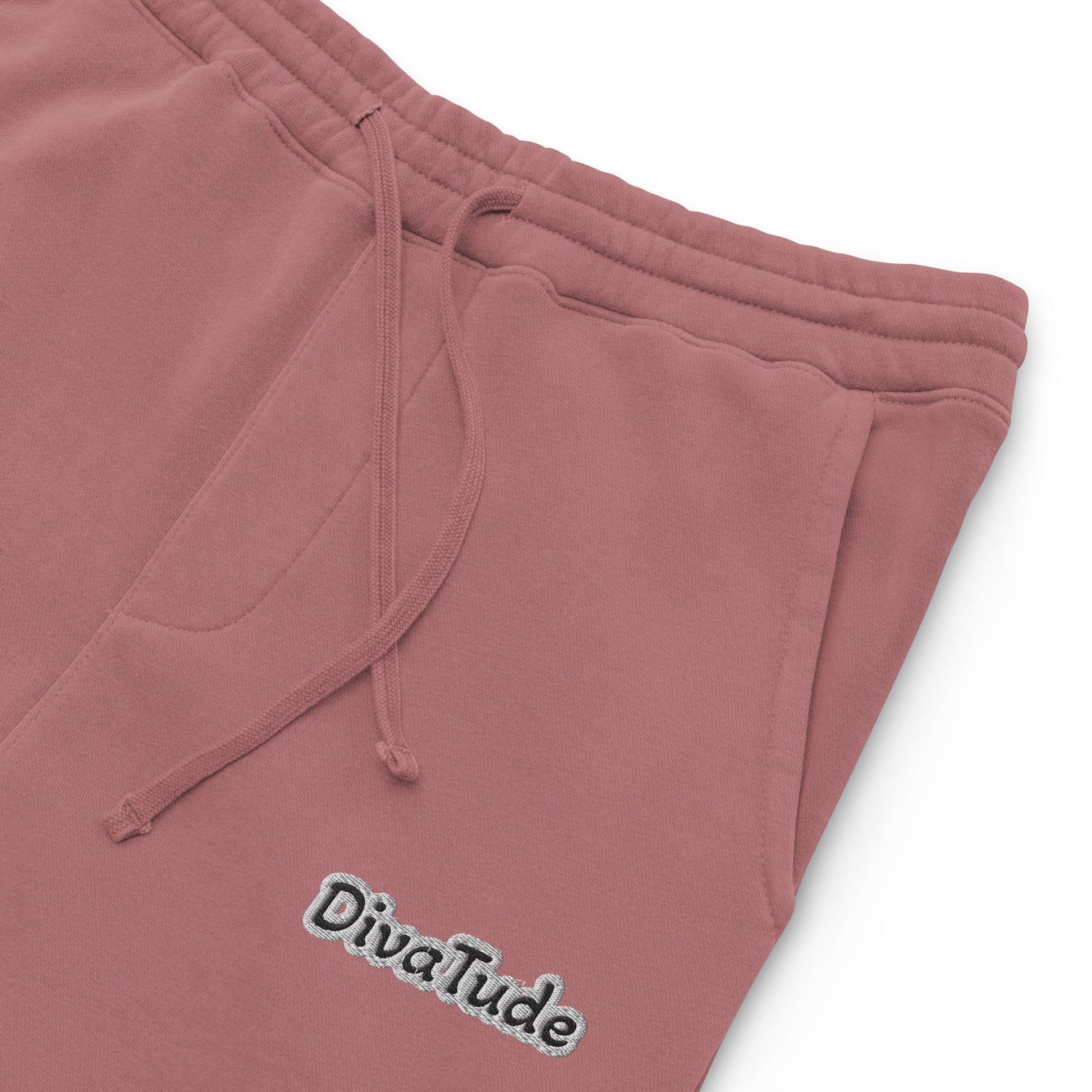 Front, left top of maroon sweatpants with black embroidered text reading 'DivaTude' at top thigh of pant