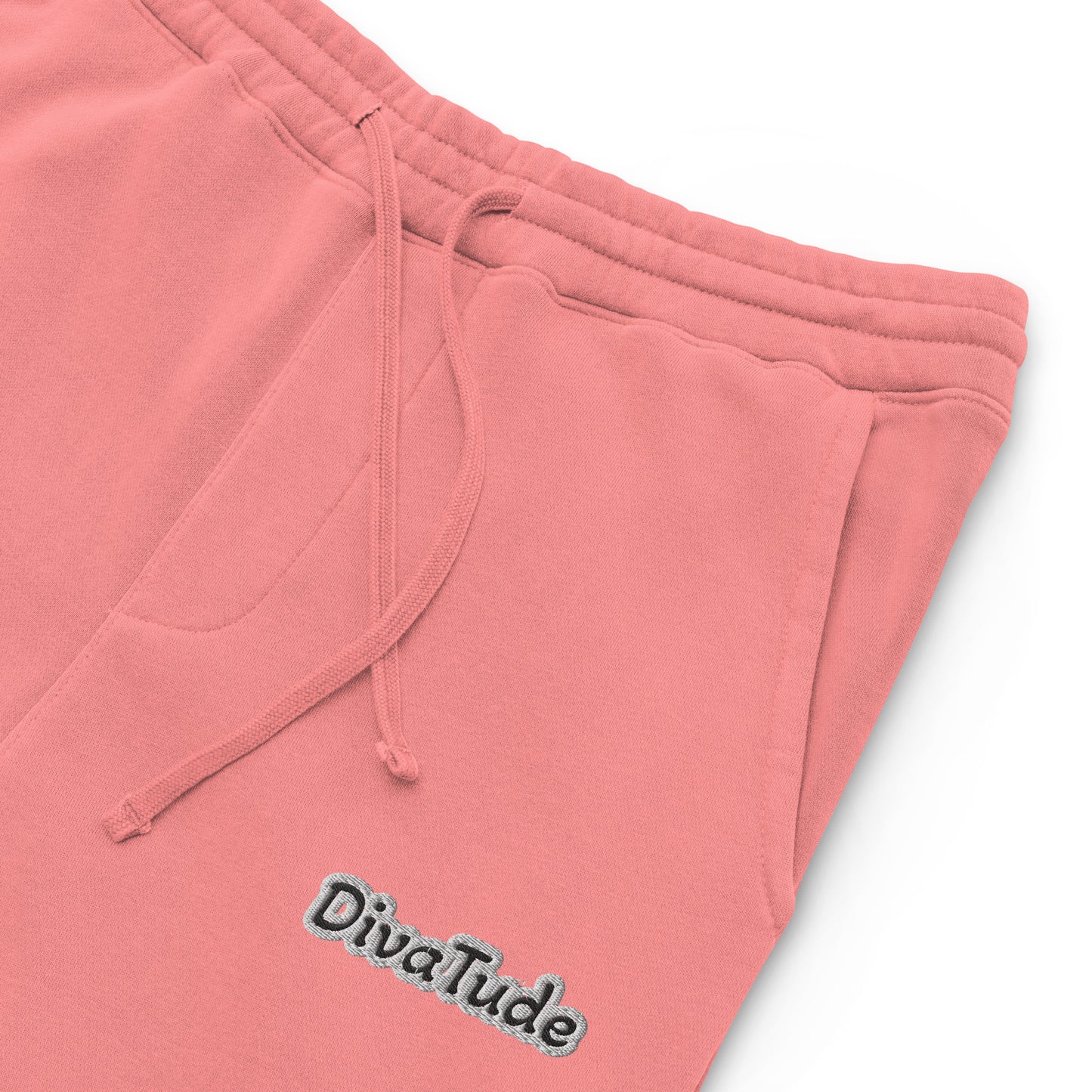 Front, left top of pink sweatpants with black embroidered text reading 'DivaTude' at top thigh of pant