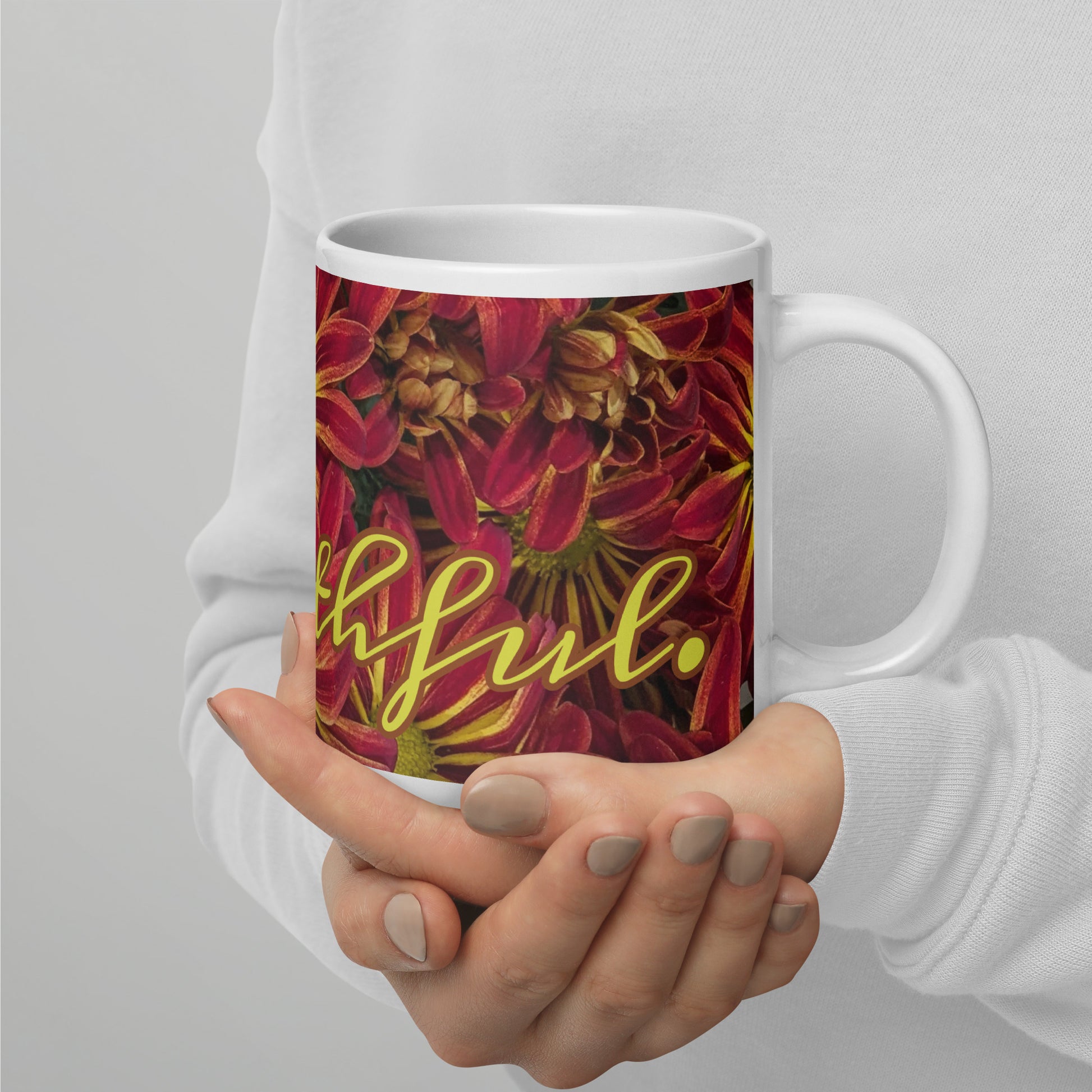 Right view of a white glossy mug with   fuchsia and yellow flowered background and partial of front view text saying 'faithful'