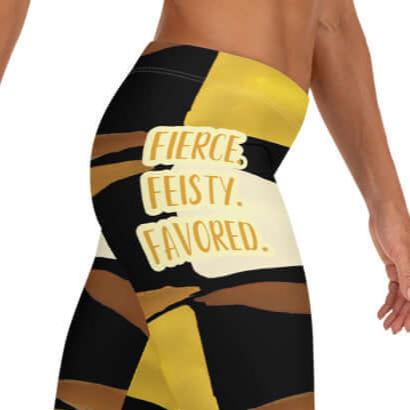 Right-side zoomed of black, brown, beige and gold print leggings with gold and white text saying 'Fierce.Feisty.Favored.' on right hip