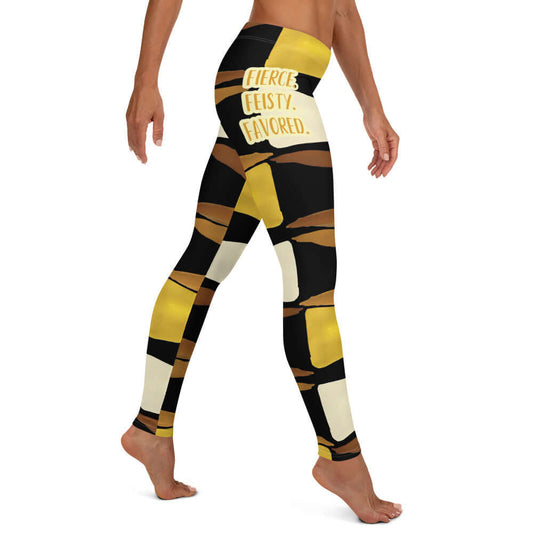 Right-side view of black, brown, beige and gold print leggings with gold and white text saying 'Fierce.Feisty.Favored.' on right hip