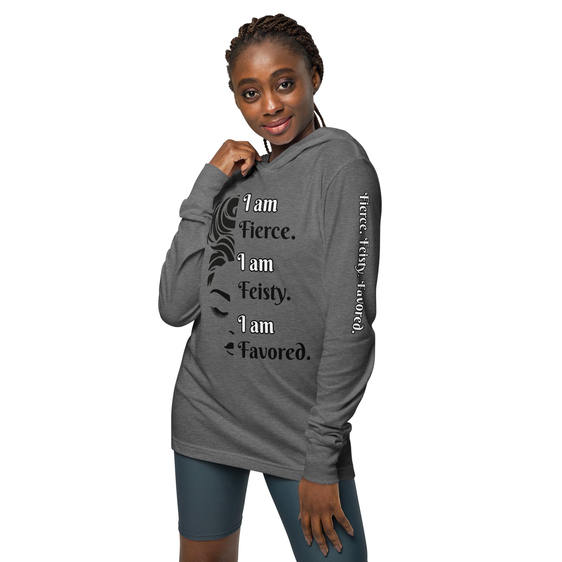 Front of grey hooded long sleeve tee with black image of 1/2 woman face and black and white text saying 'I am fierce. I am feisty. I am favored.'