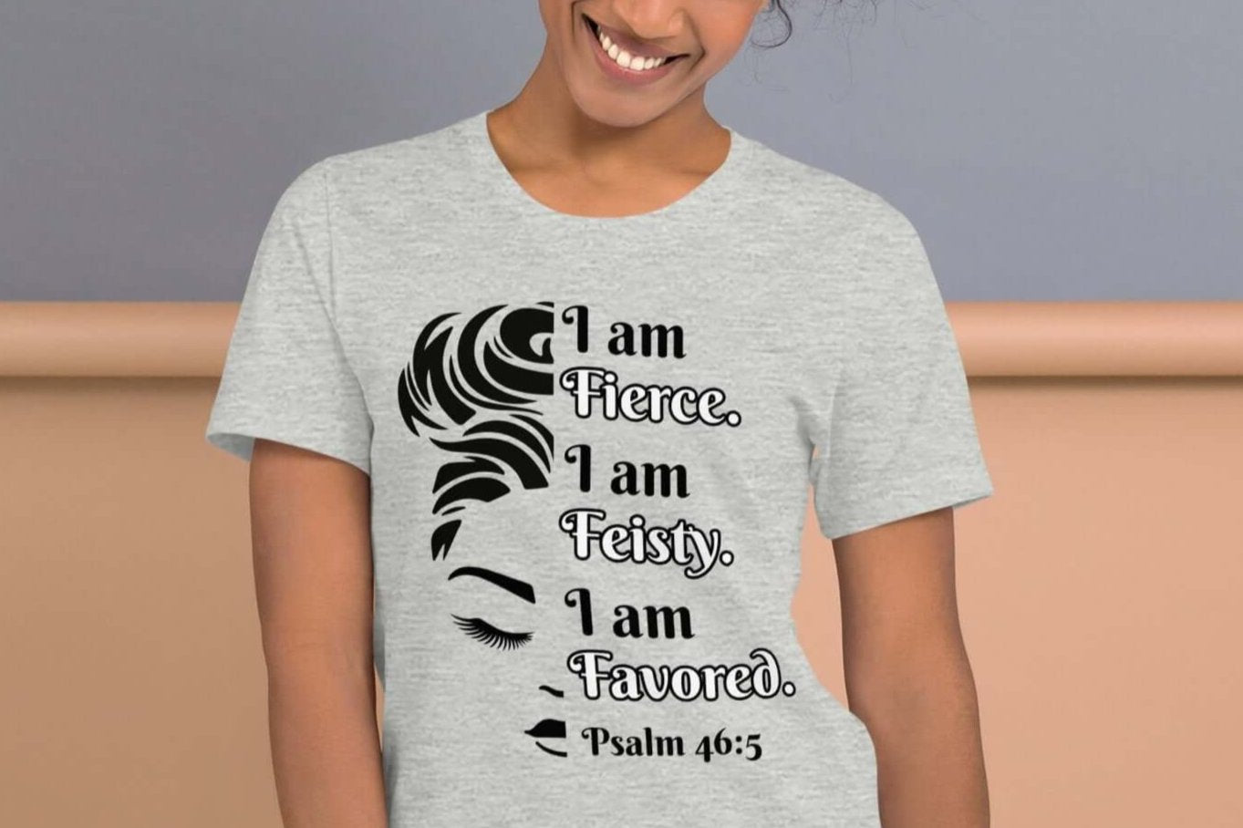 Front of heather t-shirt with image of half woman's face with black and white text saying "I am fierce, I am feisty, I am favored and Psalm 46:3'