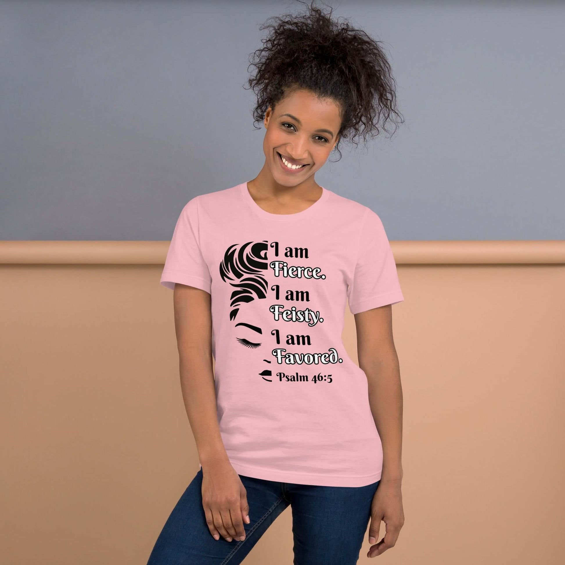 Front of pink t-shirt with image of half woman's face with black and white text saying "I am fierce, I am feisty, I am favored and Psalm 46:3'