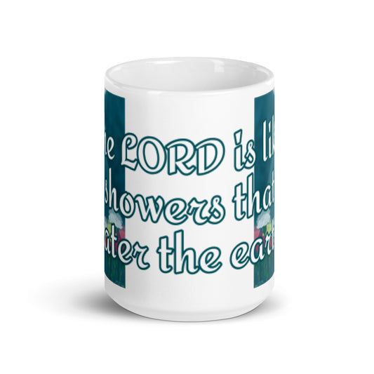 Front view of white glossy mug with blue and white text saying 'the Lord is like showers that water the earth' across the front and flower and shower illustration on both sides