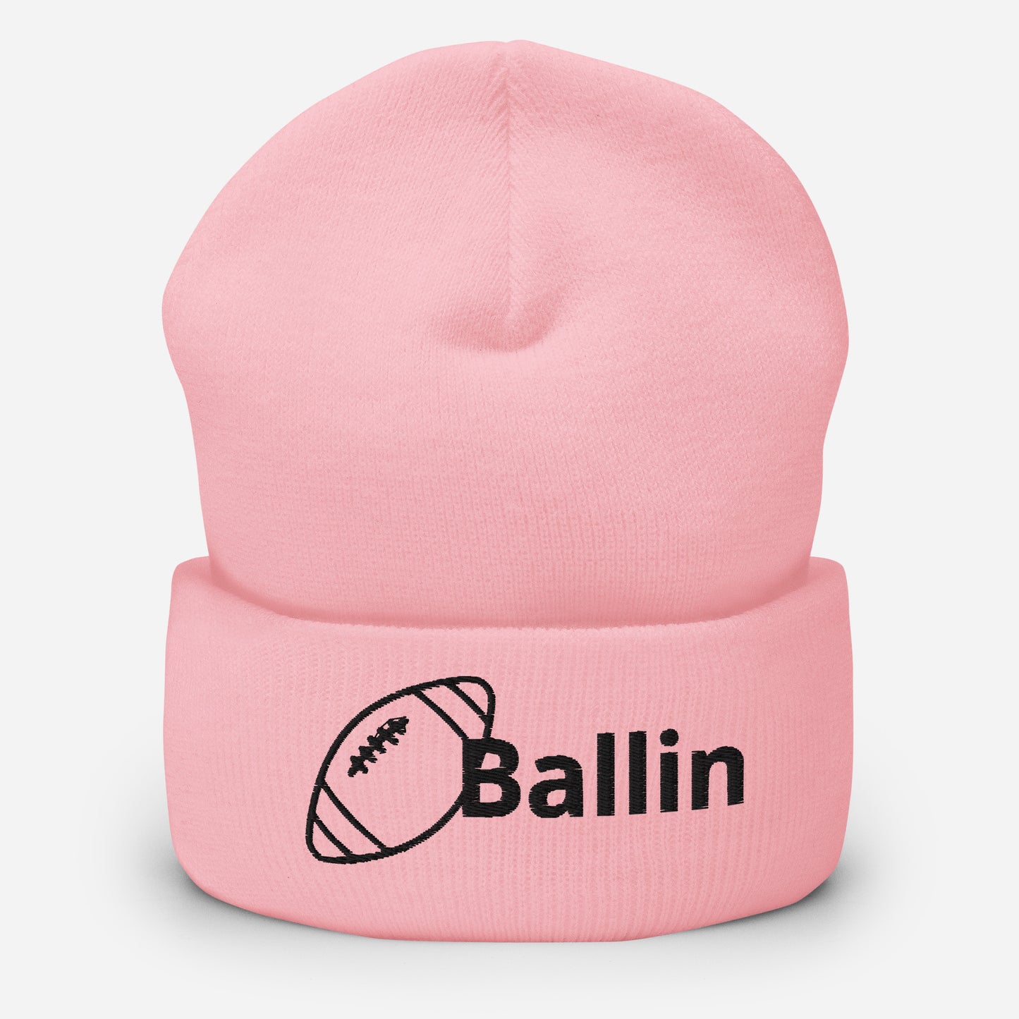 Front of pink cuffed beanie embroidered with a black football and black text saying 'ballin'