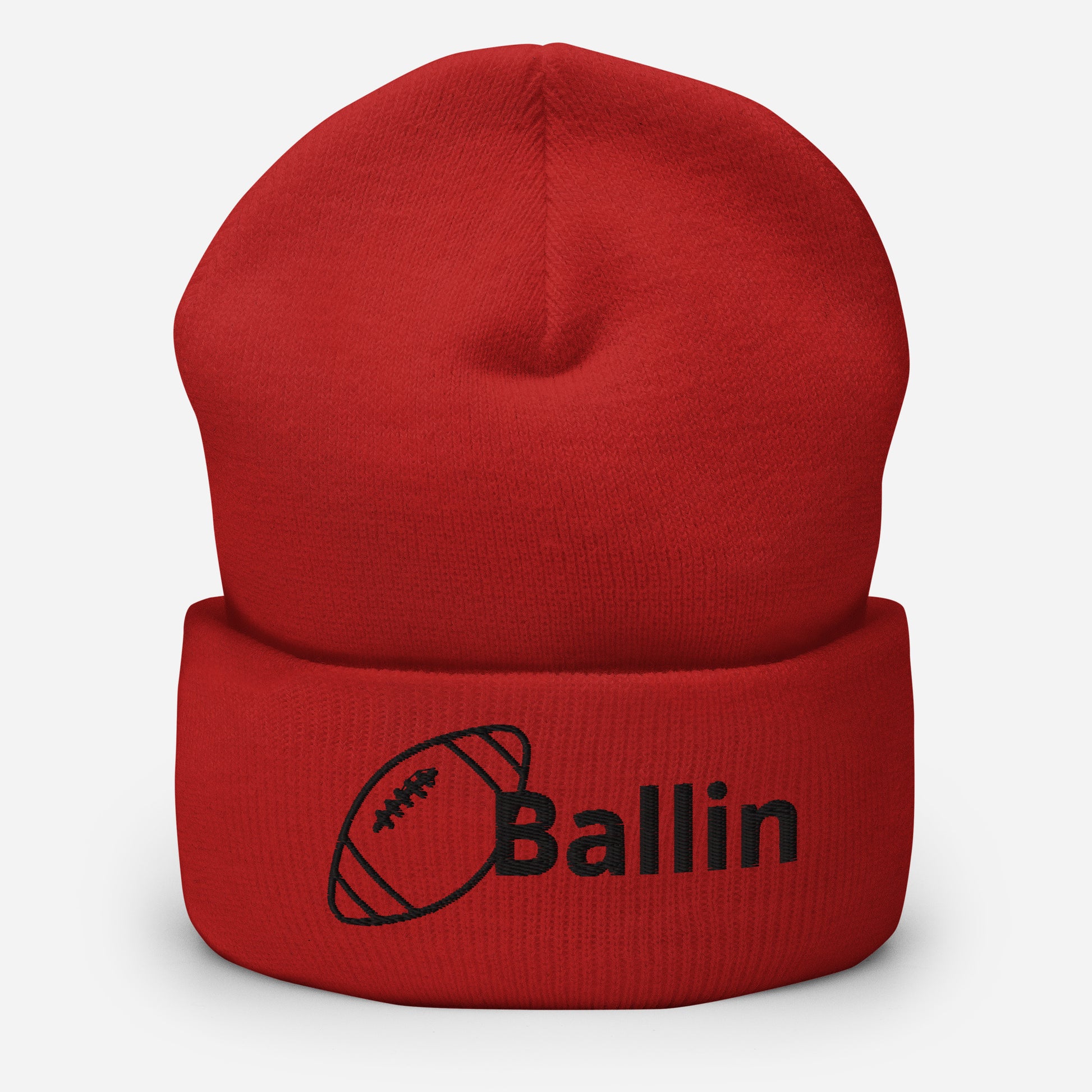 Front of red cuffed beanie embroidered with a black football and black text saying 'ballin'