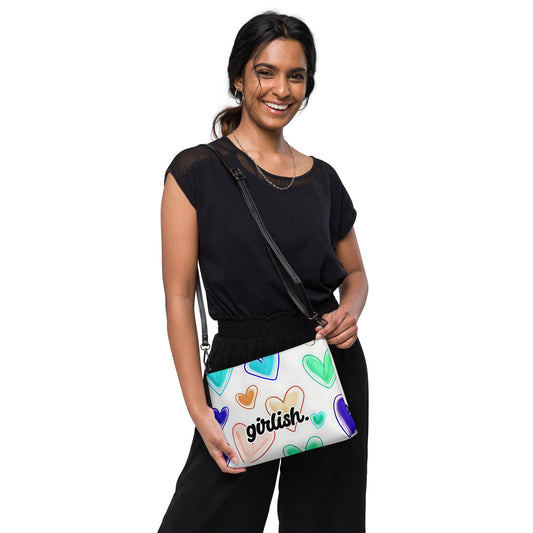 Front of crossbody bag with hearts on white background and 'girlish' text being carried 