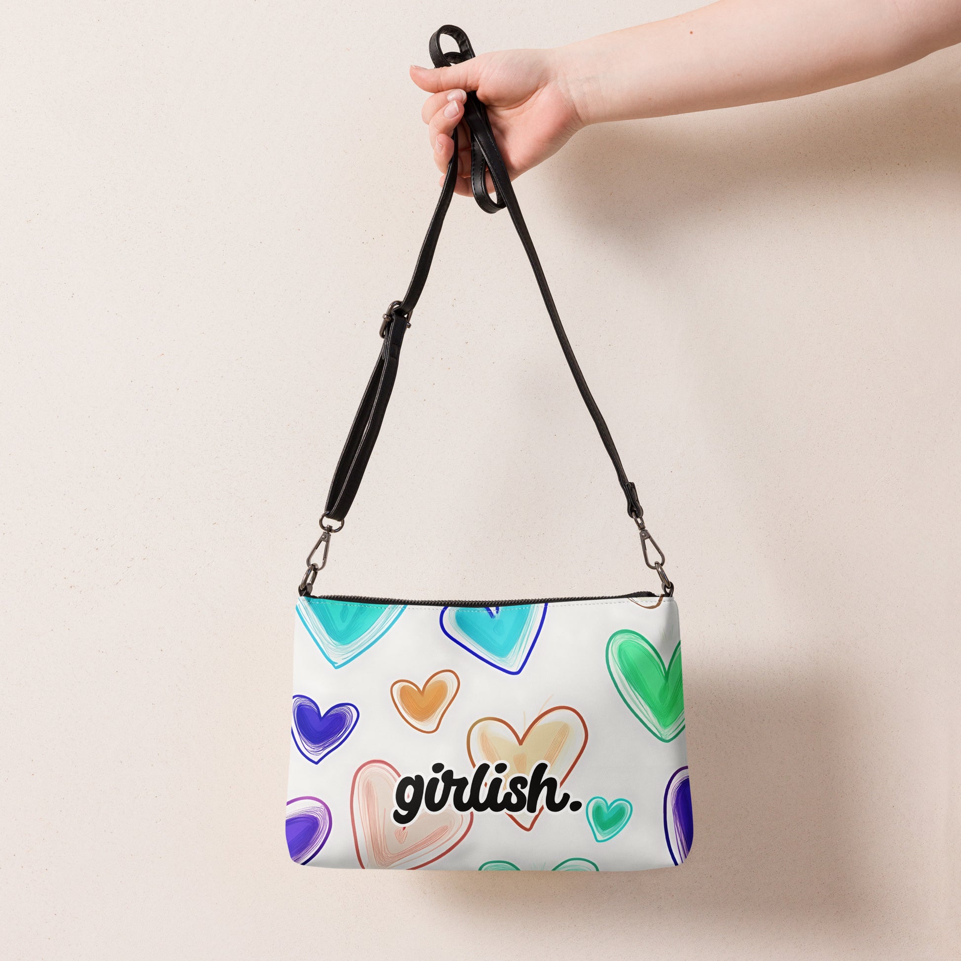 Front of crossbody bag with hearts on white background with'girlish' text
