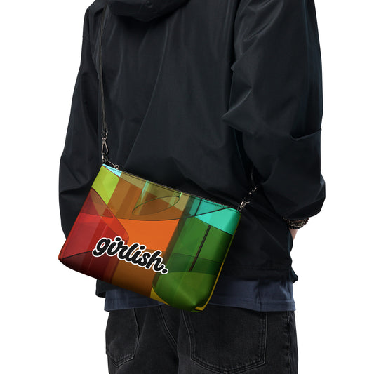 Front of crossbody bag of square pattern of brown, red, green, and gold background and word saying 'girlish' being carried