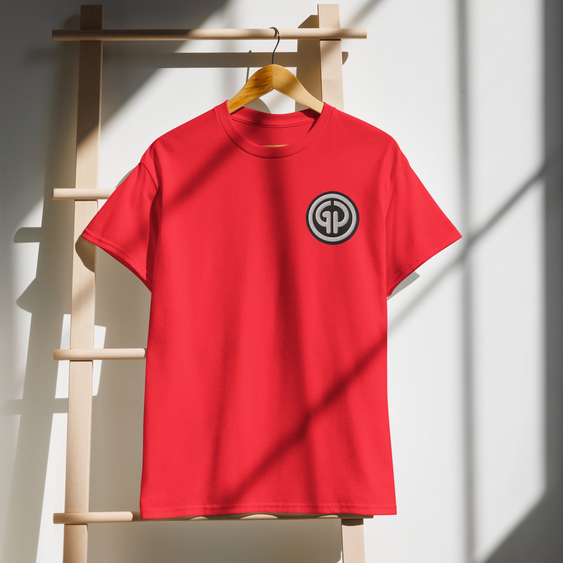 Front of hanging red t-shirt with God's Property 'GP' emblem embroidered on left chest