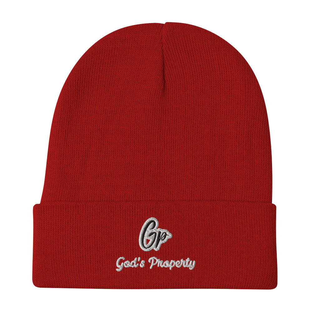 Front of red knit beanie embroidered with black and gray text saying 'GP, God's property