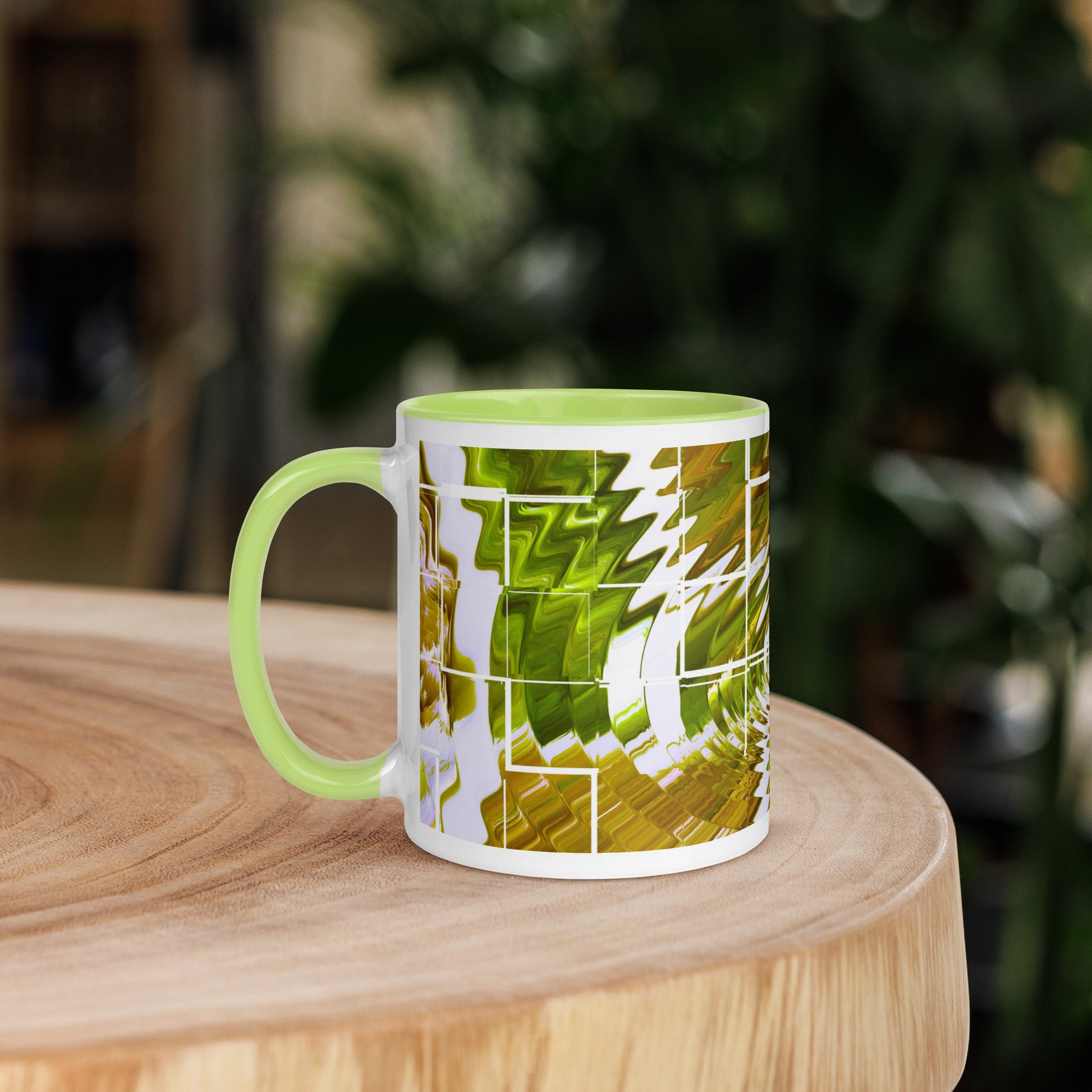 Left view of a white glossy mug light green inside and covered in a green and white abstract print background