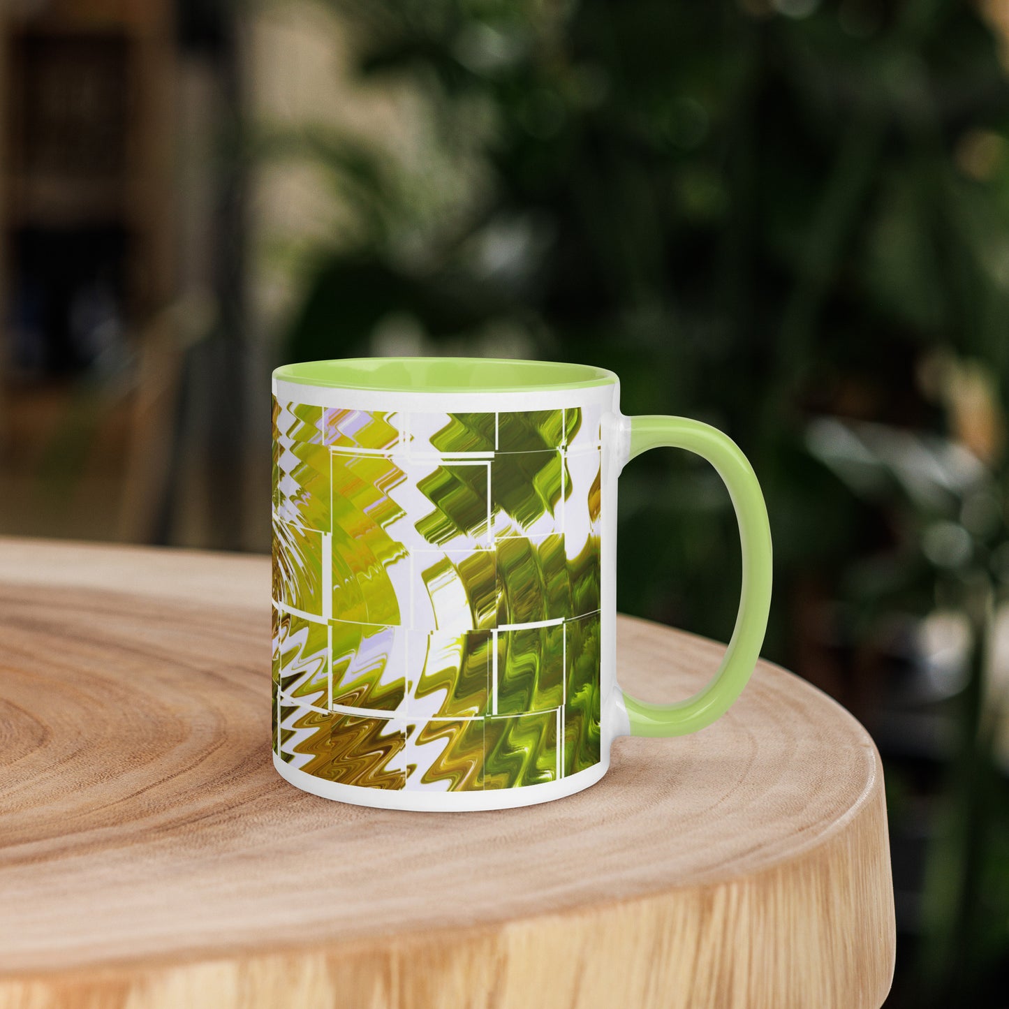 Right view of a white glossy mug light green inside and covered in a green and white abstract print background