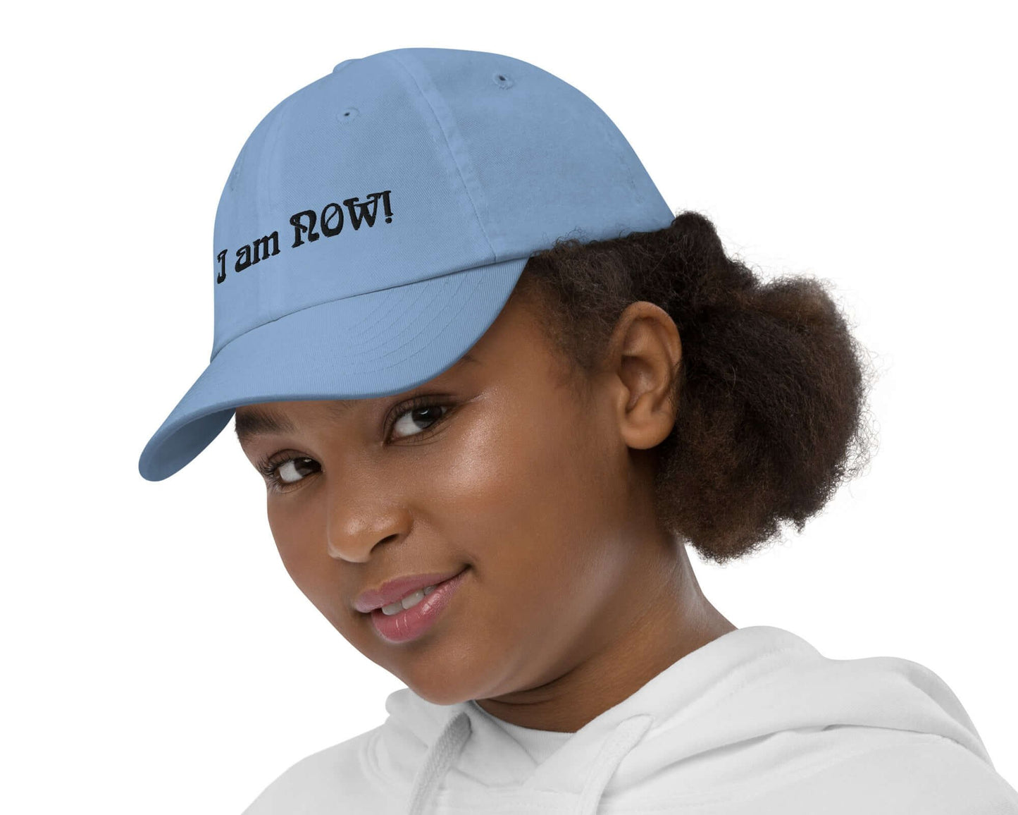 Left view of youth wearing a baby blue baseball cap with text saying 'I am now' across the front