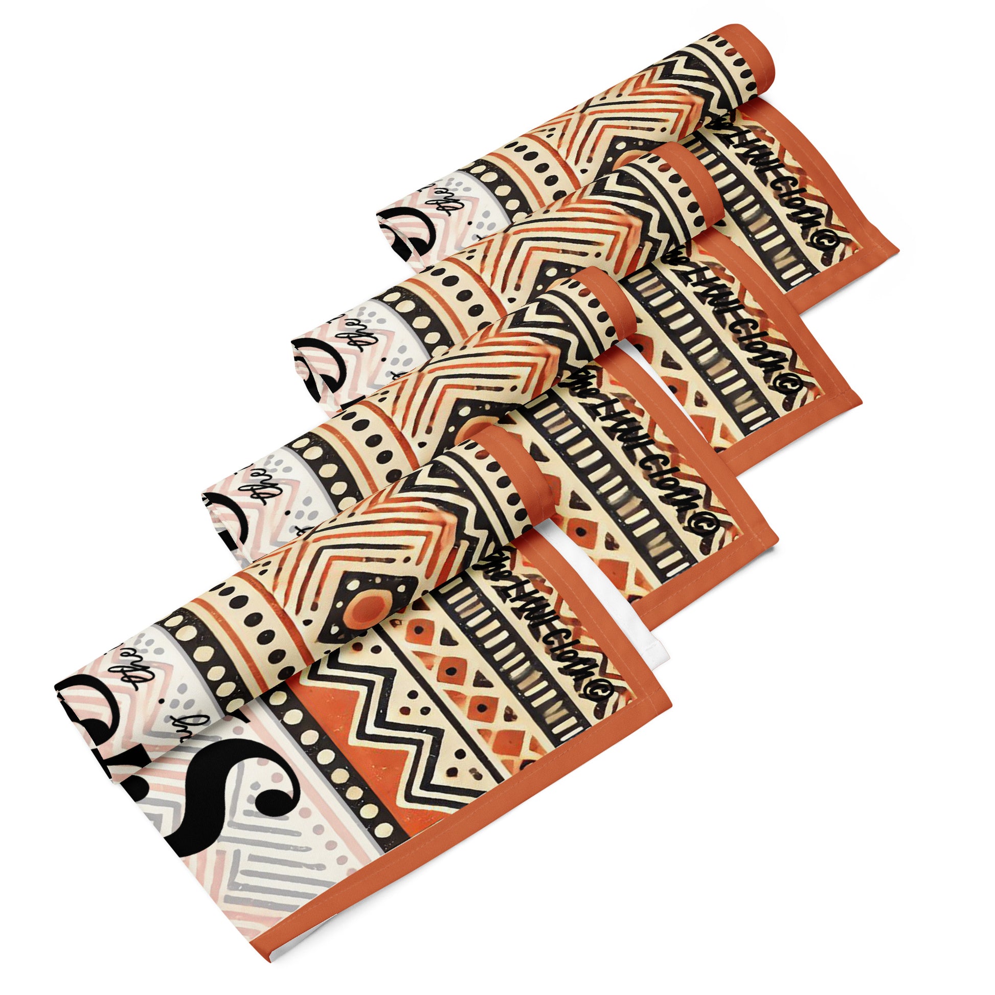Four rolled LIWI cloth with orange, beige, black and white pattern text saying 'Jesus the way, the truth, the life'