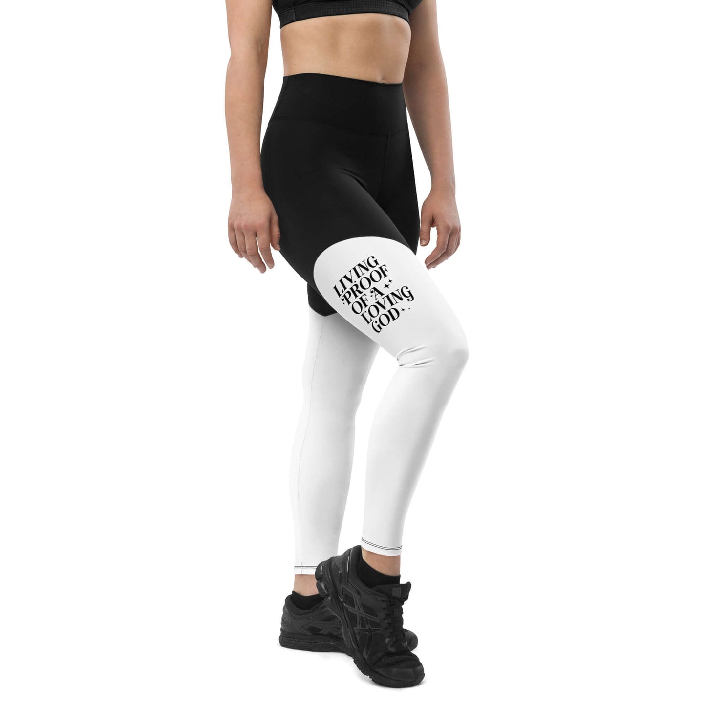 Right front of black and white leggings with black text saying 'Living proof of a loving god' on right thigh