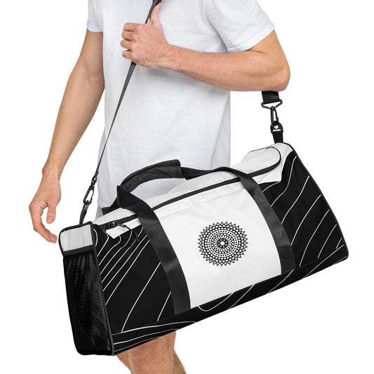 Right front of black and white print duffle bag with black mandala being carried by male