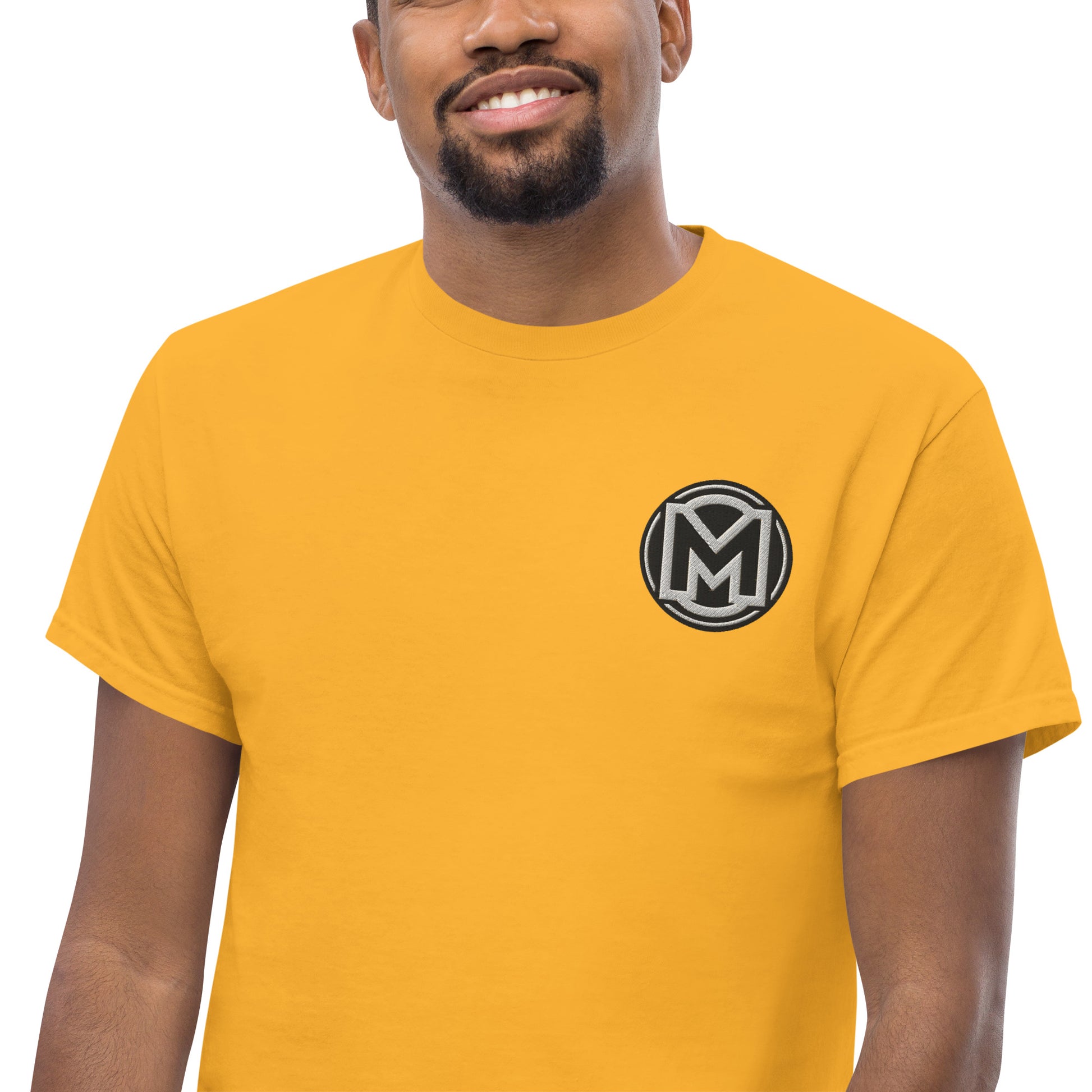 Front of gold Manly t-shirt with M logo on left chest