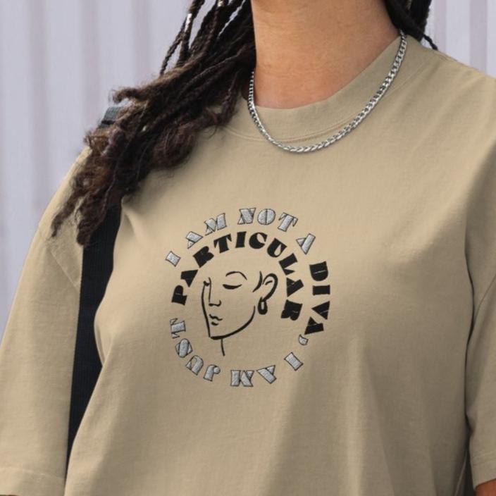 Front of khaki t-shirt with image of woman's face and text saying 'I am not a diva, I am just particular'